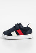 Marineblaue Sneaker aus Mesh und synthetischem Material, mit weißer Sohle, roten und weißen horizontalen Streifen an der Seite, gesichert mit einem Klettverschluss.