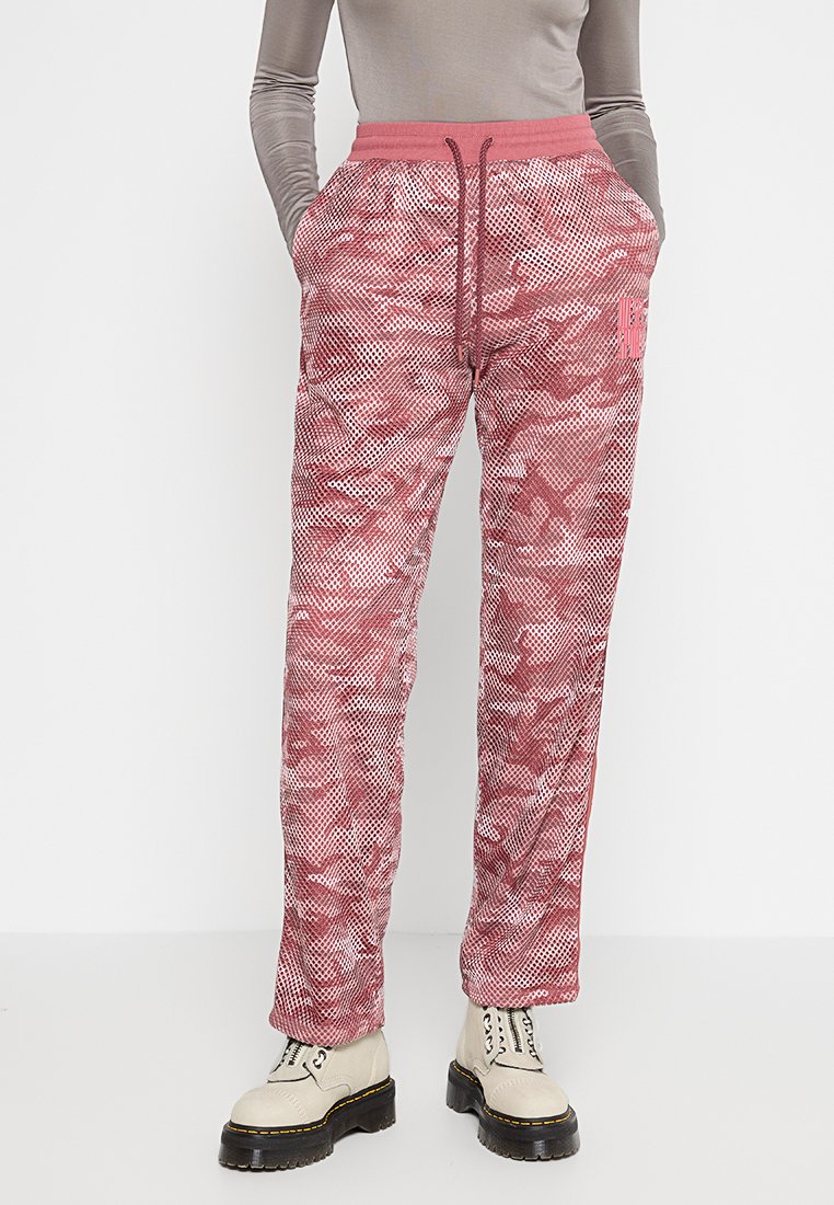Rosa und weiße gemusterte Sweatpants mit elastischem Bund, Kordelzug und Seitentaschen, die eine strukturierte, netzartige Optik haben.
