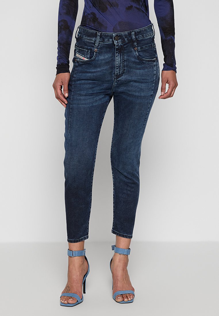 Dunkelblaue Denim-Jeans im Slim-Fit-Design, mit mittelhohem Bund, Fronttaschen und leichter Ausbleichung. Verfügt über gestickte Details und eine glatte Textur.