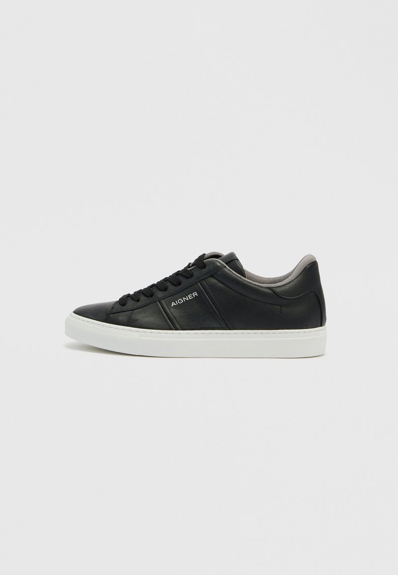 Schwarzer Ledersneaker mit kontrastierender weißer Gummisohle. Verfügt über eine glatte Textur, Schnürverschluss und schlichtes Branding an der Seite.