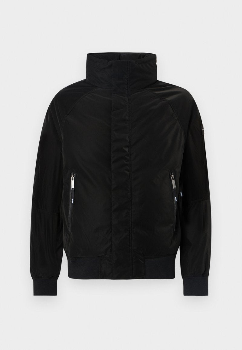 Schwarze gepolsterte Jacke mit hohem Kragen, langen Ärmeln und gerippten Bündchen. Verfügt über zwei Reißverschluss-Taschen vorne und hat ein glattes, satinähnliches Finish.