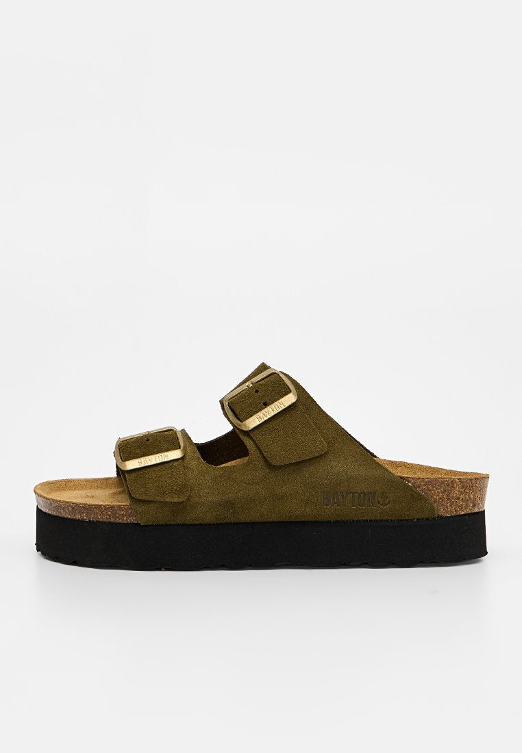 Braune Wildleder-Slipper-Sandale mit zwei verstellbaren Schnallenriemen und schwarzer Plateausohle auf weißem Hintergrund.