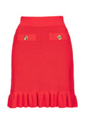 Roter gerippter Strickrock mit enger Taille, zwei Akzenttaschen mit goldenen Knöpfen und einem rüschierten Saum am unteren Ende.