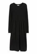 Schwarzes langärmliges Kleid mit ribbeligem Oberteil und ausgestelltem Rock. Verfügt über einen runden Halsausschnitt und eine glatte Stofftextur.