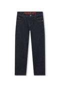 Dunkelblaue Denim-Jeans verfügen über einen geraden Schnitt, ein Fünf-Taschen-Design und kontrastierende Nähte. Der Bund zeigt ein rotes Logo-Label.