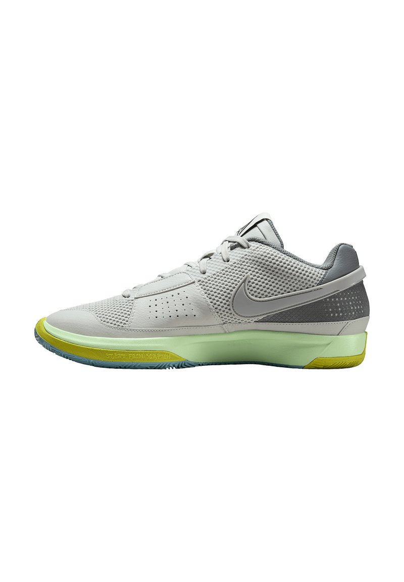 Nike-Sportschuh in Hellgrau mit einem Obermaterial aus Mesh, grünen und gelben Akzenten, flacher Außensohle und strukturiertem Design. Abgerundete Zehenpartie und Schnürverschluss.