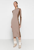 Rippstrick-Kleid mit langen Ärmeln in Beige, mit braunen Seitenpaneelen und einem Viertel-Reißverschlusskragen. Stylisch kombiniert mit cremefarbenen und beigen Stiefeletten.