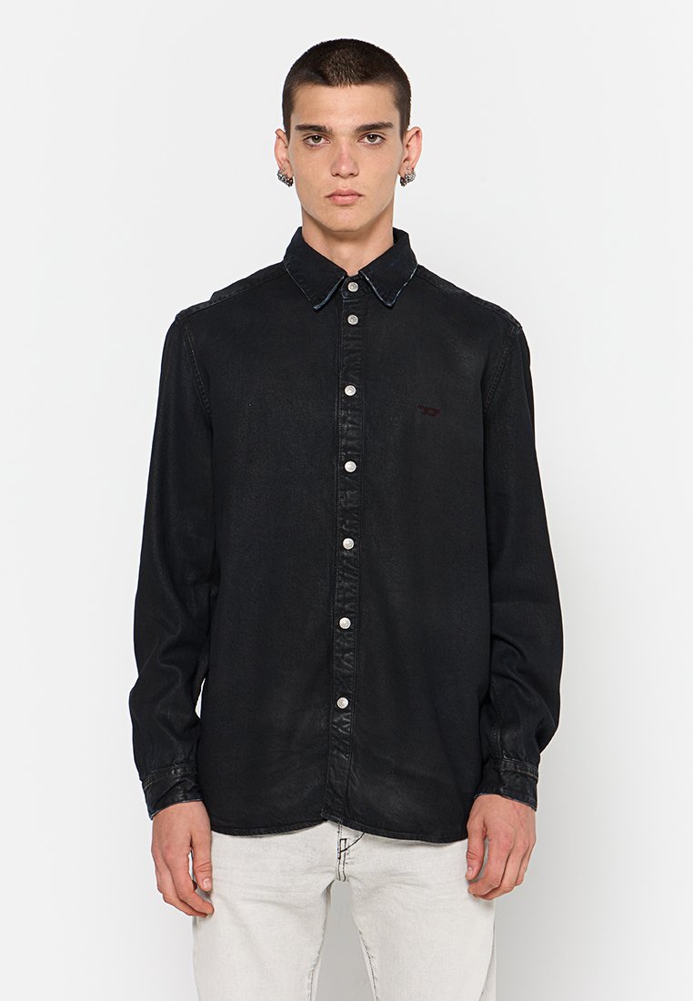 Schwarzes Denim-Hemd mit Knöpfen und einem kontrastierenden dunklen Kragen, silbernen Knöpfen und einem dezenten Logo auf der linken Brust. Lange Ärmel.