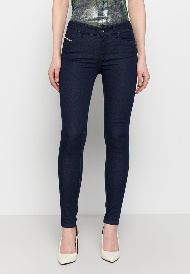 Dünne dunkelblaue Jeans aus Denim, ausgestattet mit einem klassischen Fünf-Taschen-Design, frontalen Knopfverschluss und subtilen Nähdetails.
