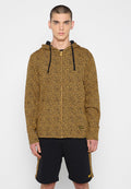 Kapuzensweatjacke mit einem gelb-schwarzen Leopardenmuster, ausgestattet mit einer Kängurutasche und schwarzen Kordeln. Kombiniert mit schwarzen Shorts.