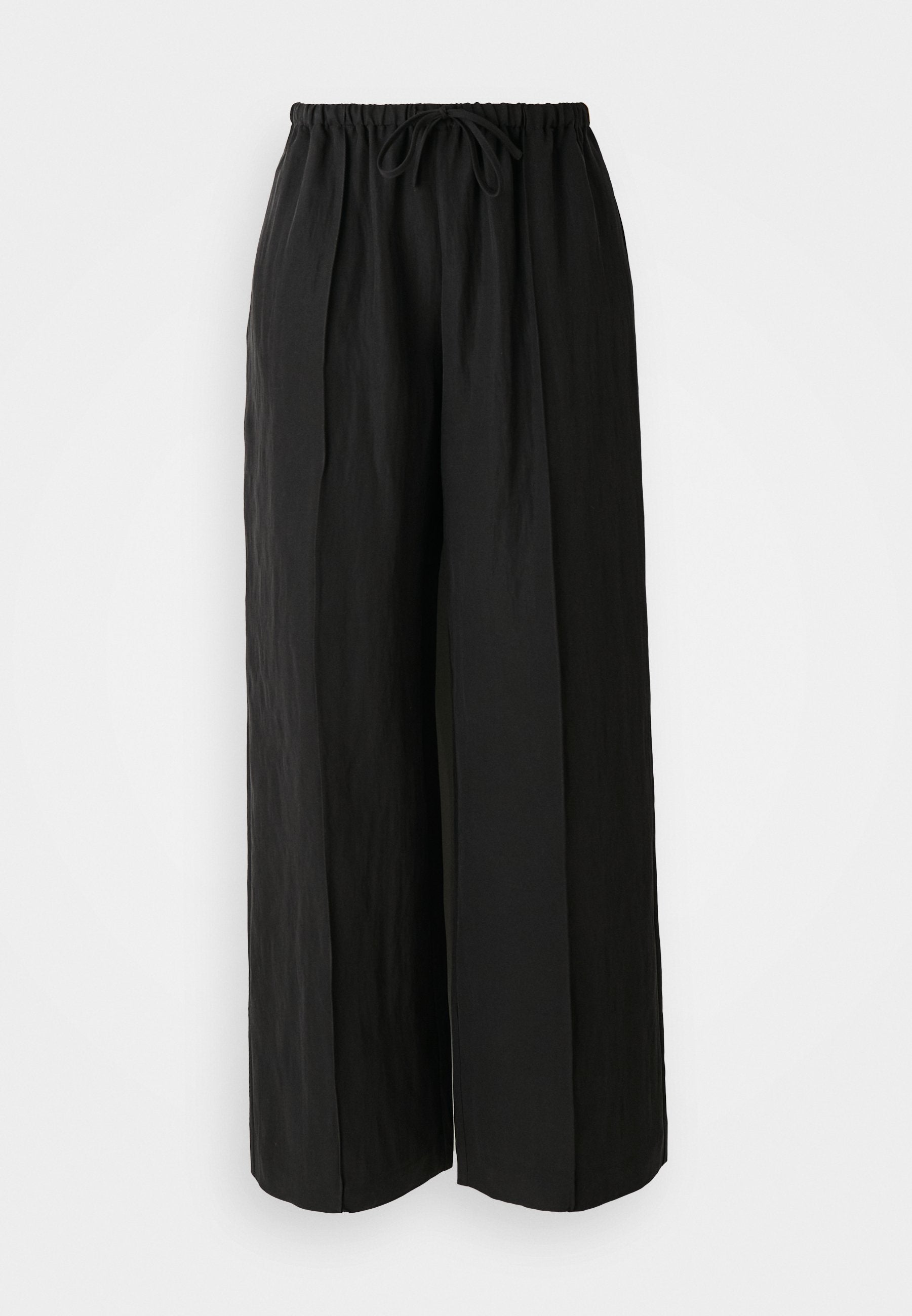 Schwarze weit geschnittene Hose aus strukturiertem Stoff. Sie verfügen über einen dehnbaren Bund mit Kordelzug und vertikalen Falten für zusätzliche Details.