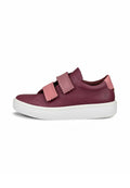 Niedrig geschnittene bordeauxfarbene Leder-Sneaker mit zwei rosa Klettverschlüssen und weißer gerippter Sohle, seitlich auf einem weißen Hintergrund gezeigt.