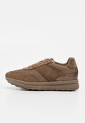Brauner Sneaker aus Wildleder und Mesh mit Schnürung vorne, gepolsterter Sohle und metallischem Akzent an der Ferse, seitlich auf weißem Hintergrund gezeigt.