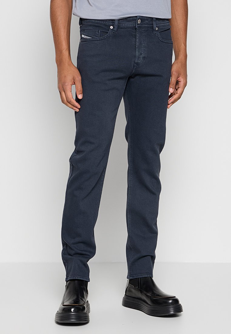 Dunkelblaue Jeans im Slim-Fit-Stil mit klassischem Fünf-Taschen-Design, Metallknopfverschluss und dezenten Stickdetails.
