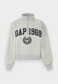 Hellgraues Sweatshirt mit Viertel-Reißverschluss, auf der Vorderseite in der Mitte mit "GAP 1969" in dunkelblauen Buchstaben und einem Herzemblem unter dem Text.