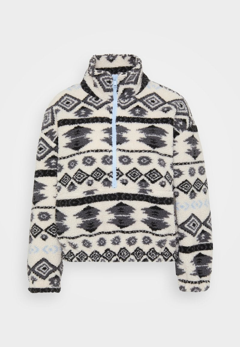 Fleece-Pullover mit einem halben Reißverschluss, der ein geometrisches Muster in Schwarz und Grau auf einem cremefarbenen Hintergrund sowie hellblauen Reißverschlussakzenten zeigt.