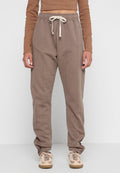 Braune Sweatpants mit schmal zulaufendem Design, elastischem Bund und Kordelzug. Verfügt über Seitentaschen und sichtbare Steppnähte für Textur.