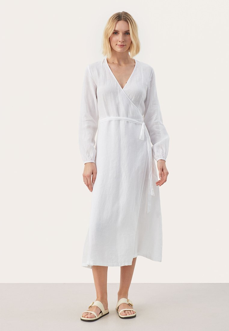 Weißes Leinen-Wickelkleid mit langen Ärmeln und einem Bindeband, das einen tiefen V-Ausschnitt und eine fließende Midi-Länge besitzt. Glatte Textur und minimalistisches Design.
