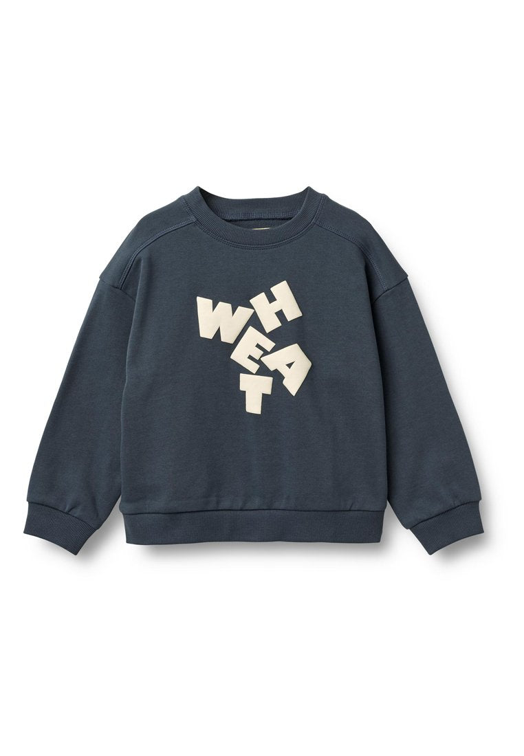 Dunkelblauer Pullover mit Rundhalsausschnitt, Raglanärmeln und strukturierten, cremefarbenen Buchstaben, die das Wort "WHEAT" in verschiedenen Ausrichtungen auf der Vorderseite bilden.