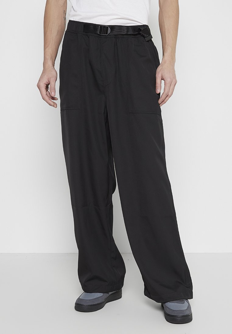 Schwarze Cargo-Hosen aus leichtem Stoff, mit lockerer Passform, elastischen Bündchen und einem Gürtel, sowie mehreren vorderen Taschen für Funktionalität.