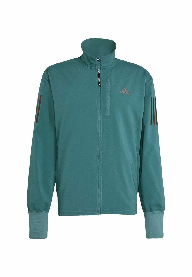 Türkisfarbene Sportjacke aus glattem, leichtem Material. Sie hat einen hohen Kragen, einen Reißverschluss vorne und drei dunkle Streifen auf den Schultern.