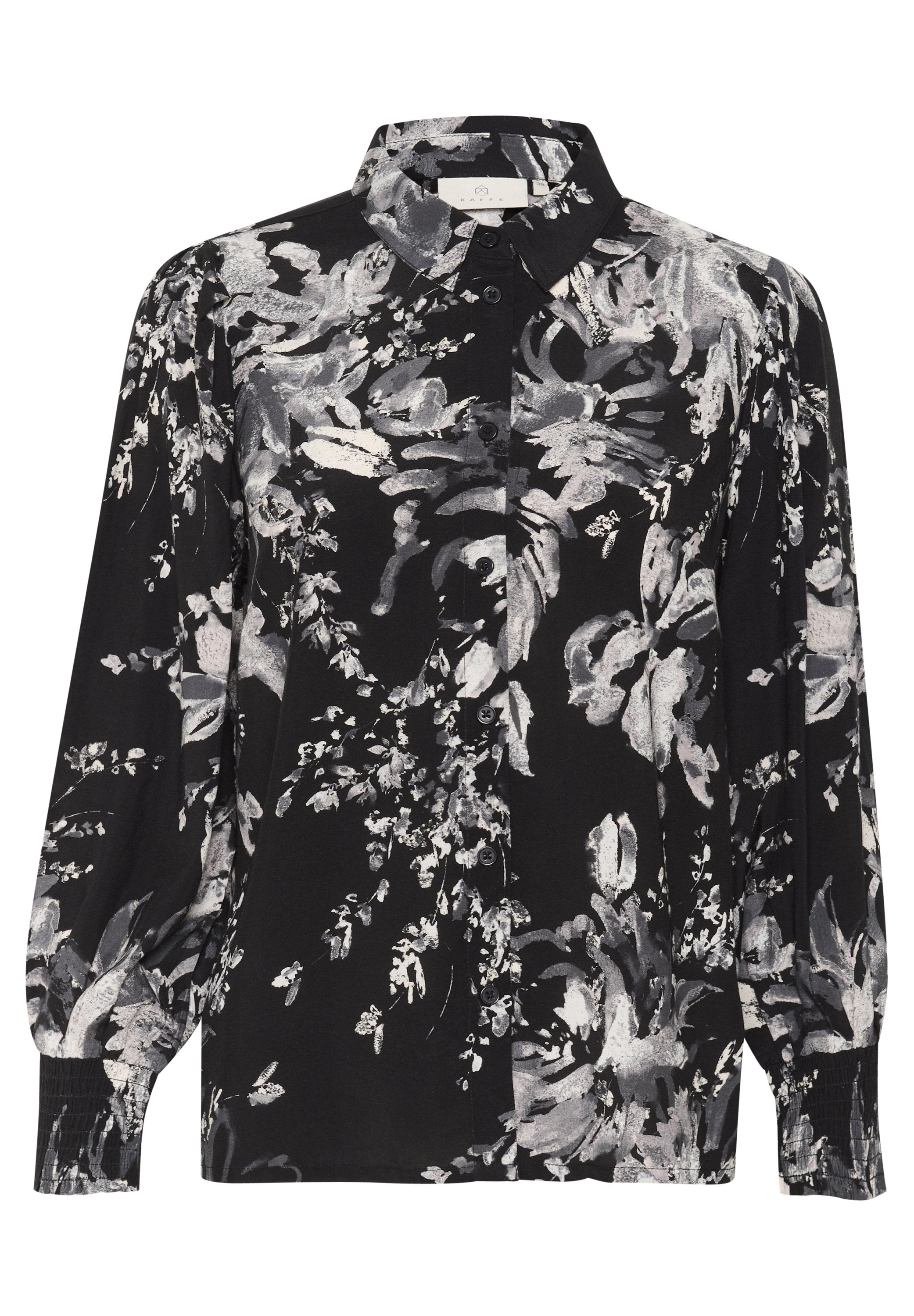 Schwarze Bluse mit grauen und weißen Blumenmustern. Mit einem kragenförmigen Ausschnitt, durchgehender Knopfleiste und gerafften langen Ärmeln.