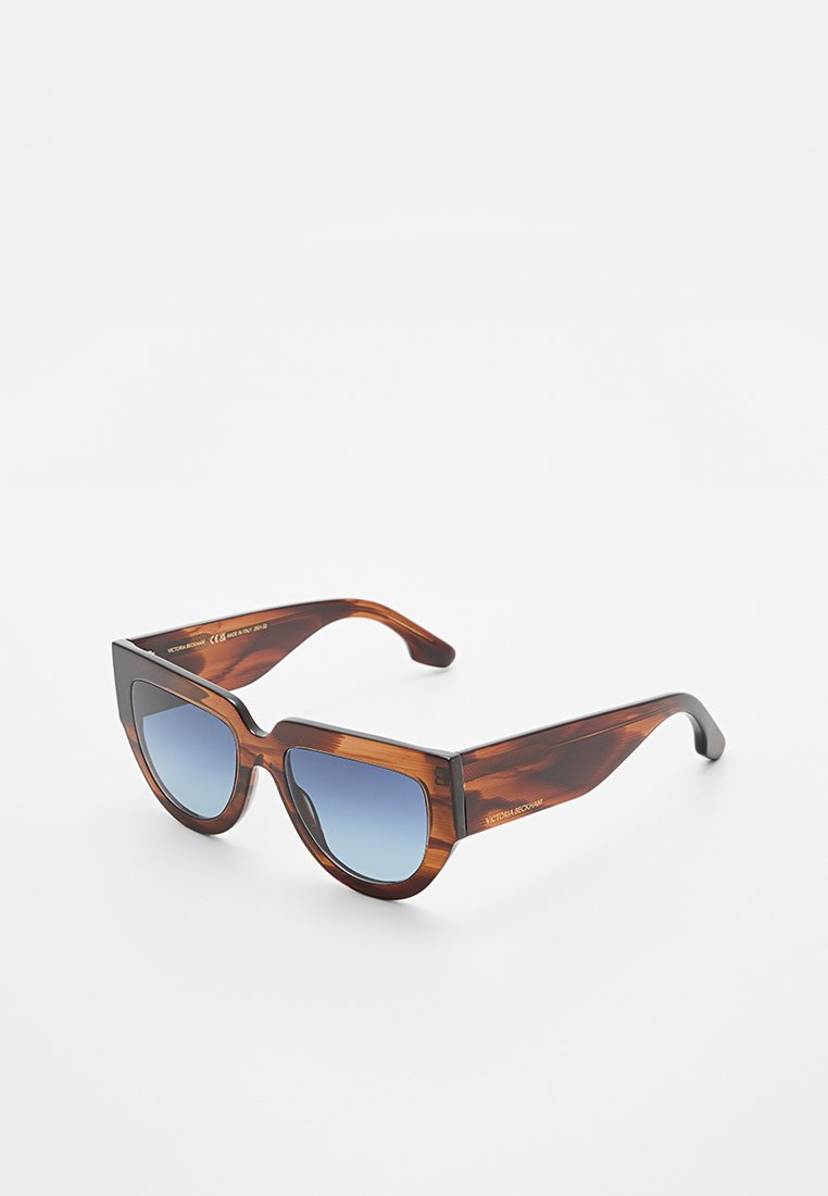 Schildpatt-Katzenaugen-Sonnenbrille mit blauen Verlaufslinsen, breiten Bügeln und eingeätztem Markennamen an der Seite.