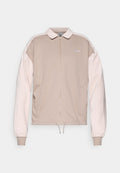 Beige Nike Zip-Up-Jacke mit hellpinkfarbenen Ärmeln, Kragen, elastischen Bündchen und Kordelzugsaum. Gesticktes Logo auf der Brust.