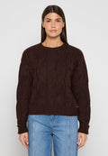 Brauner Strickpullover mit strukturiertem Muster, rundem Ausschnitt und gerippten Bündchen. Kombiniert mit hellblauen Jeans für einen Kontrast.