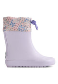 Fliederfarbener Gummiregenstiefel mit einem hellrosa Stoffbündchen mit Blumenmuster. Ebenfalls mit einem lila Knebelverschluss und einer profilierten Sohle für besseren Halt ausgestattet.