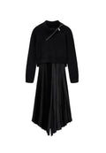 Schwarzer, kurzer Pullover mit hohem Kragen und Reißverschlussdetails, kombiniert mit einem schwarzen, plissierten Satковых Rock. Beide Teile sind weich und texturiert.