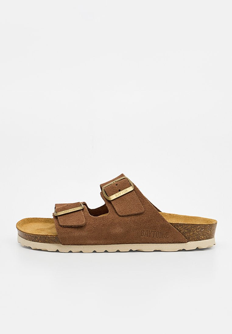 Braune Wildleder-Pantolette mit zwei verstellbaren Riemen und goldenen Schnallen, konturiertem Korkfußbett und weißer strukturierter Sohle.