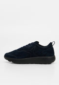 Dunkel marineblaue Wildleder-Sneaker mit schwarzer dicker Sohle, Schnürverschluss vorne und Zuglasche an der Ferse, seitlich auf weißem Hintergrund dargestellt.