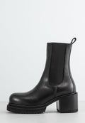 Schwarze Leder-Ankle-Boots mit einem klobigen Absatz, elastischem Seitenpanel, runder Zehenpartie und charakteristischer strukturiertem Sohlenprofil. Sauberes und minimalistisches Design.