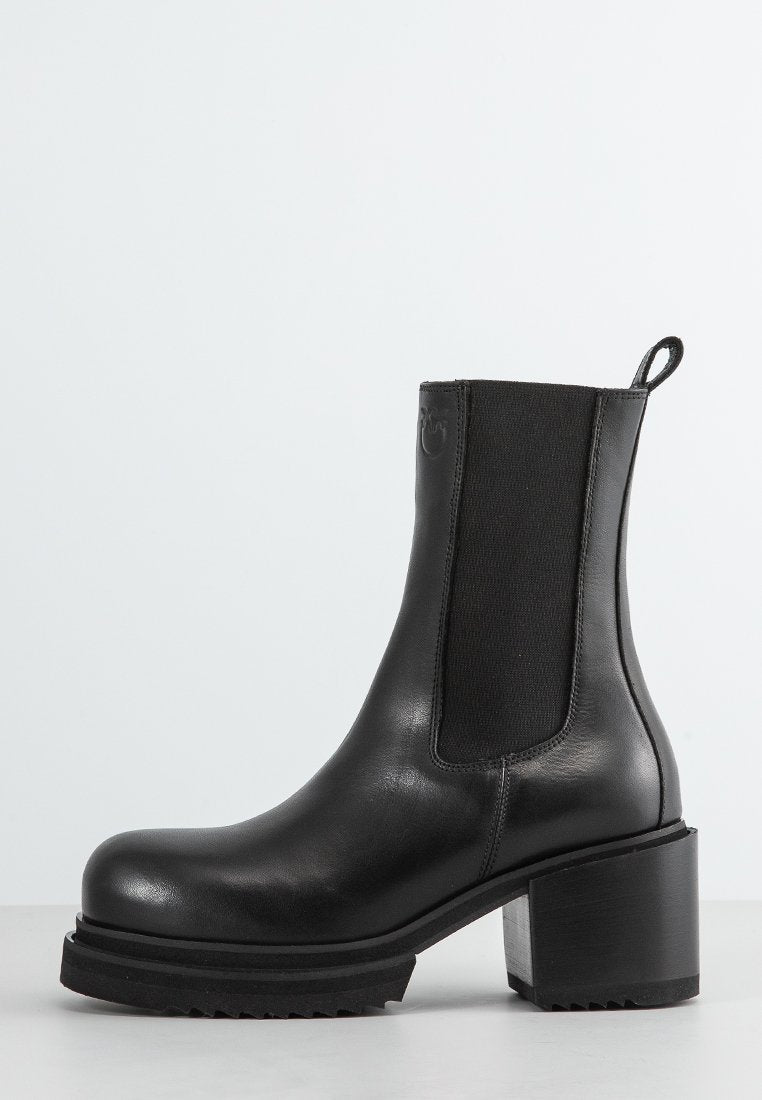 Schwarze Leder-Ankle-Boots mit einem klobigen Absatz, elastischem Seitenpanel, runder Zehenpartie und charakteristischer strukturiertem Sohlenprofil. Sauberes und minimalistisches Design.