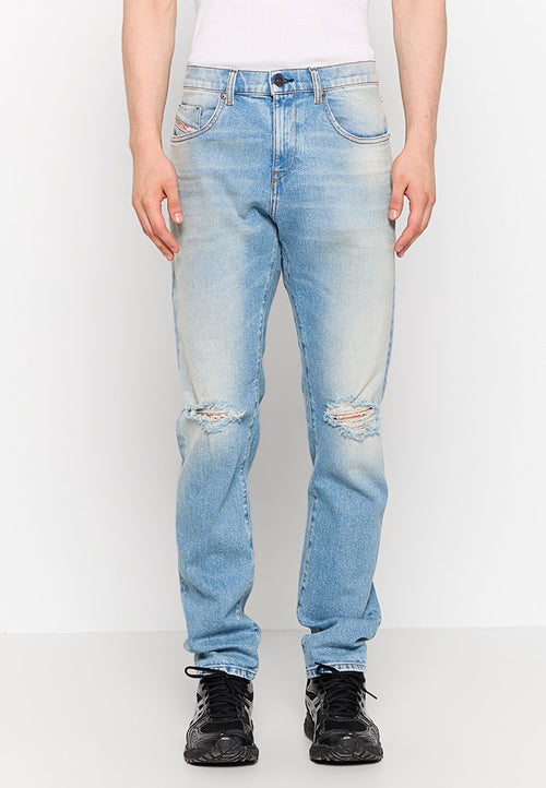 Hellblaue Jeans aus Denim mit einem lässigen Schnitt, die verwitterte Stellen und ausgebleichte Abschnitte aufweisen. Ausgestattet mit fünf Taschen und Knopfverschlussdetails.