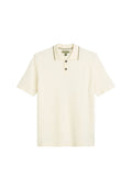 Helles cremefarbenes Polo-Shirt mit einer Drei-Knopf-Leiste, kontrastierenden dunklen Kanten am Kragen und kurzen Ärmeln. Strukturiertes Stoff-Finish.