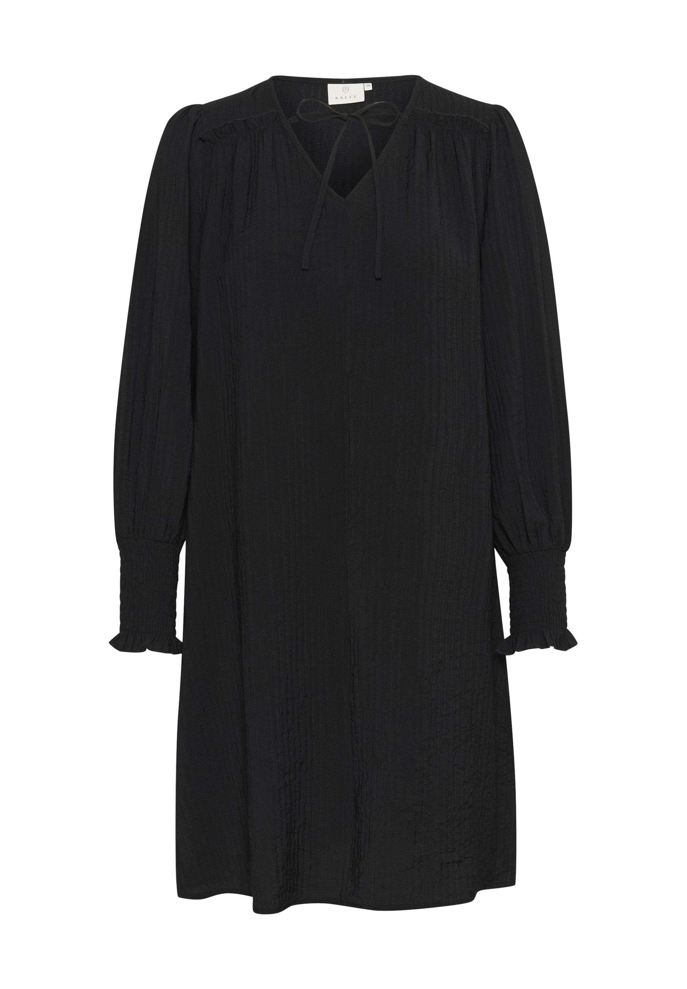 Schwarzes Kleid aus strukturiertem Stoff, mit V-Ausschnitt, langen Puffärmeln mit Rüschen an den Bündchen und einer Schleifendetail am Ausschnitt.