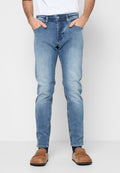 Eng anliegende Jeans aus hellblauem Denim mit Verwaschungen, fünf Taschen und Knopfverschluss in der Taille. Kombiniert mit braunen Slippern.