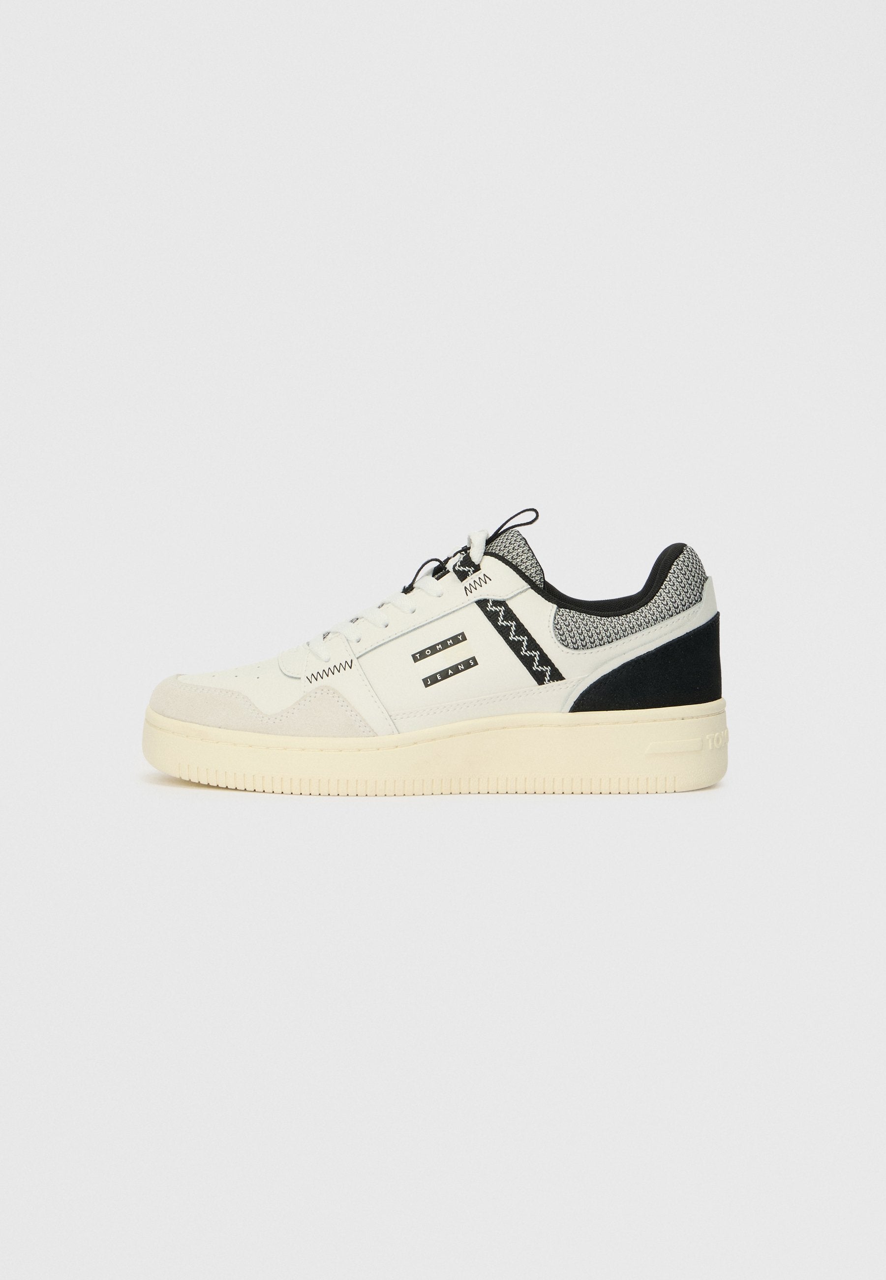 Weiße Sneaker mit einem strukturierten Obermaterial aus Wildleder und Leder, schwarzen Akzenten, einem Netzkragen, Schnürdesign und einer dicke Gummisohle.