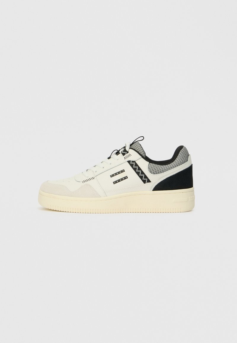 Weiße Sneaker mit einem strukturierten Obermaterial aus Wildleder und Leder, schwarzen Akzenten, einem Netzkragen, Schnürdesign und einer dicke Gummisohle.