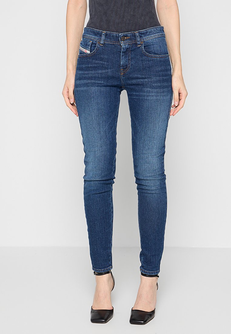 Schmal geschnittene dunkelblaue Jeans mit einer glatten Textur. Verfügt über fünf Taschen und kontrastierende Nähte. Der Saum endet am Knöchel.