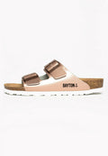 Brauner Kork-Sandalenfußbett mit zwei metallischen roségoldenen Riemen und verstellbaren Schnallen. Weiße Laufsohle mit strukturiertem Oberflächen und Branding.