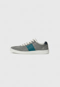 Graue Wildleder-Sneaker mit einem türkisfarbenen Lederakzentstreifen, weißer Gummisohle und weißen Schnürsenkeln. Verfügt über ein Low-Top-Design und minimales Branding.