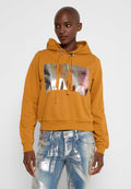 Senfgelb Hoodie mit glänzendem silbernen Grafikdruck, Zugbandkapuze und cropped Design. Kombiniert mit hellblauen, distressed Jeans.