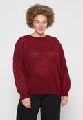 Burgunderfarbener, locker gestrickter Pullover mit langen Ärmeln, Rundhalsausschnitt und geripptem Saum. Der Stoff hat eine strukturierte, leicht durchsichtige Optik.