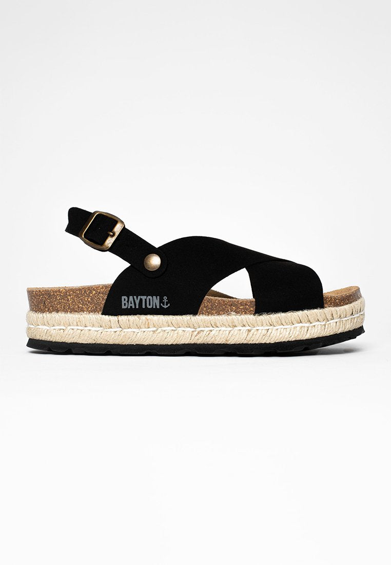 Schwarze Wildledersandale mit Korkfußbett, geflochtenem Jute-Zwischensohlen und verstellbarem Schnallenriemen. Besitzt ein geschwungenes Design und ein Logodetail.