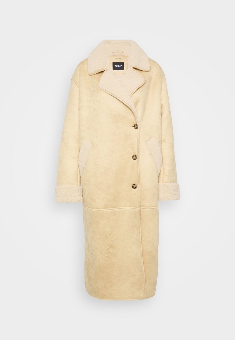 Beige Kunstfellmantel mit einem Reverskragen, großen Knöpfen, seitlichen Taschen und strukturiertem Stoff. Lange Ärmel mit umgeschlagenen Bündchen.