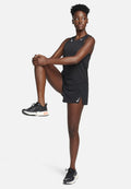 Schwarzes sportliches Tanktop mit durchbrochenem Design, kombiniert mit schwarzen Shorts. Getragen mit schwarzen Laufschuhen mit orangen Akzenten.