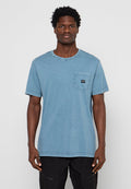 Blaues Baumwoll-T-Shirt mit Rundhalsausschnitt, kurzen Ärmeln und einer Brusttasche mit einem kleinen schwarzen Logo-Patch. Glatte Textur und lässige Passform.